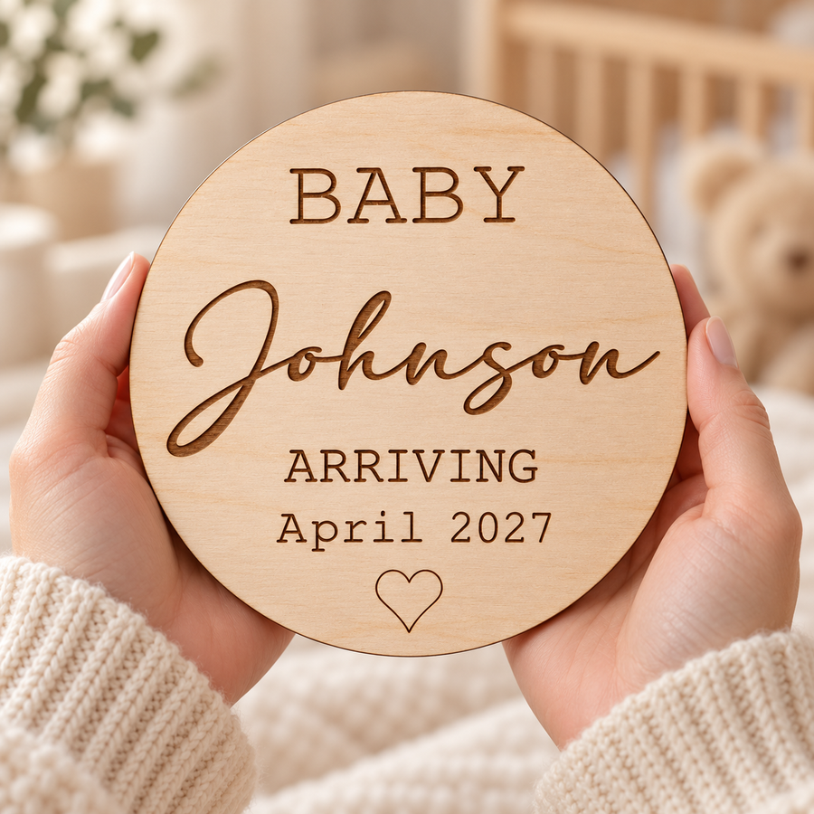 Personalised Baby Arriving sign held in hands, with Johnson surname and April 2027 engraving