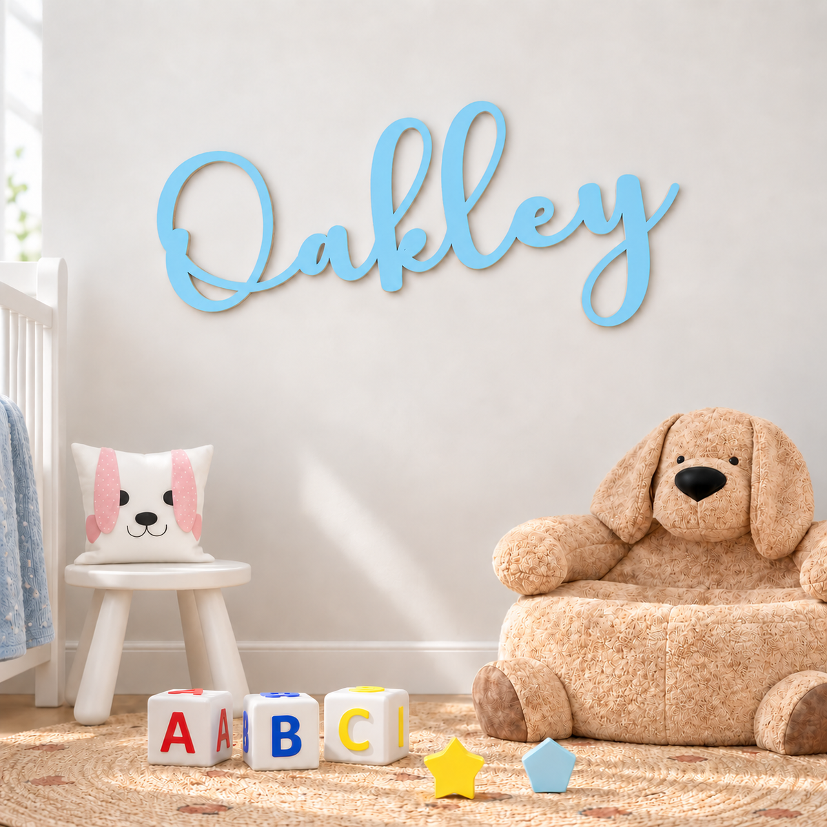 Pastel blue Oakley wooden name letters on a nursery wall above a cosy children's play corner