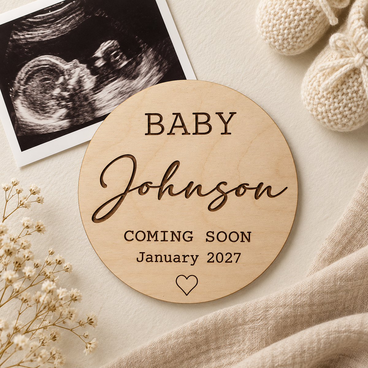 Round Coming Soon wooden plaque styled beside a baby scan photograph