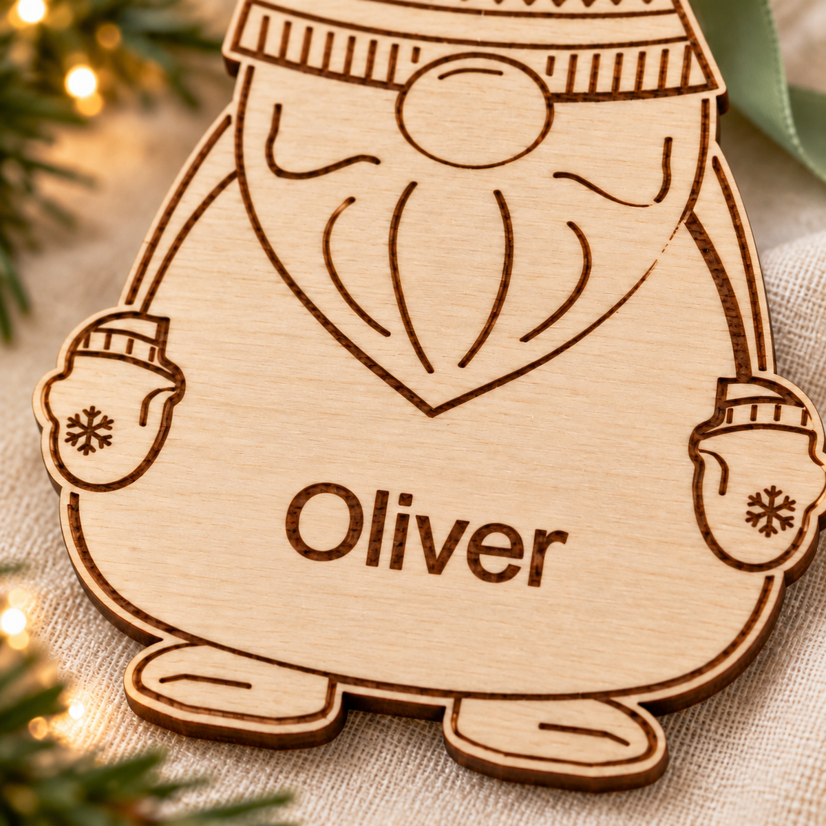 Close-up of the engraved name and winter details on a natural birch plywood gnome Christmas ornament.