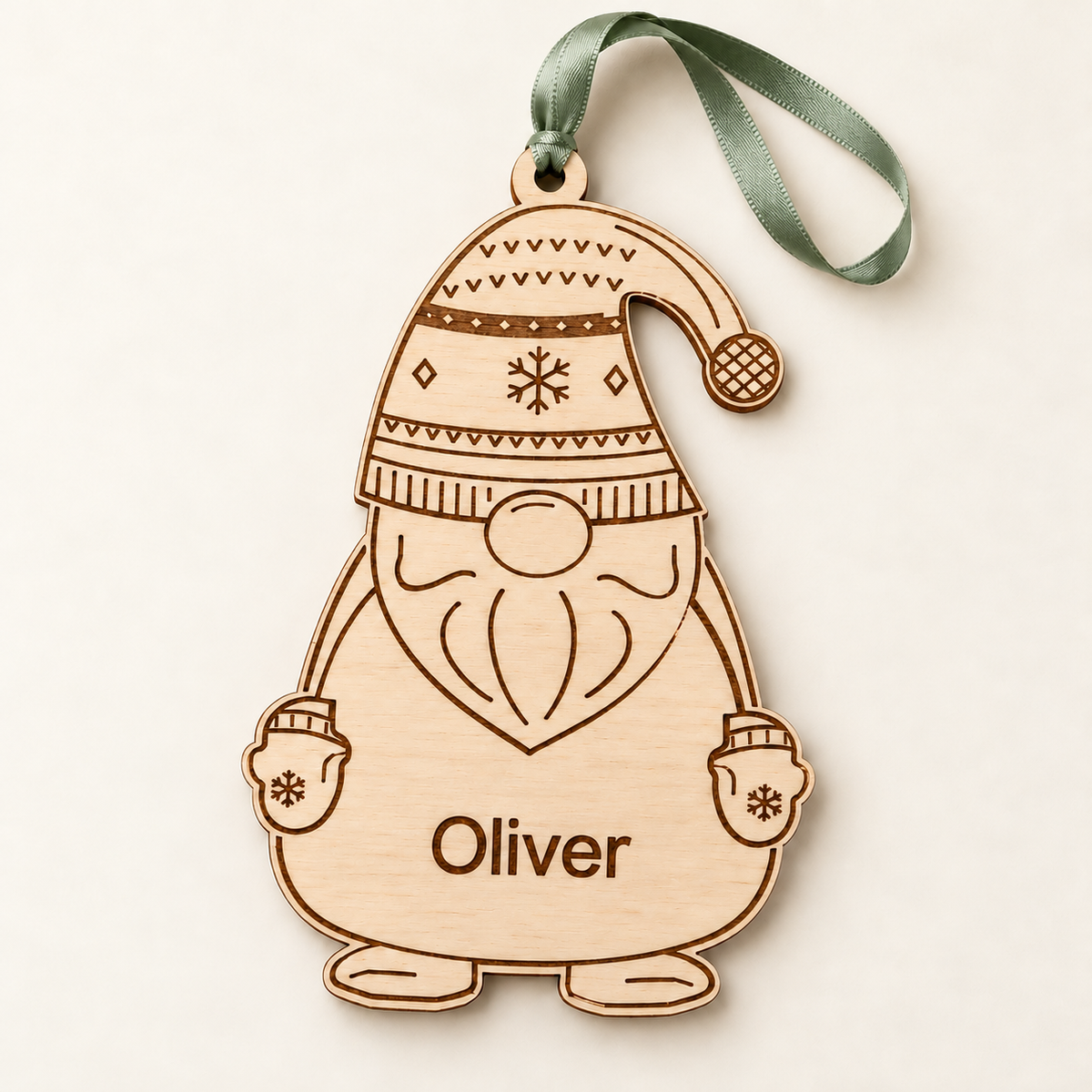 Full front view of the personalised Oliver wooden gonk bauble with a sage green ribbon against an ivory background.