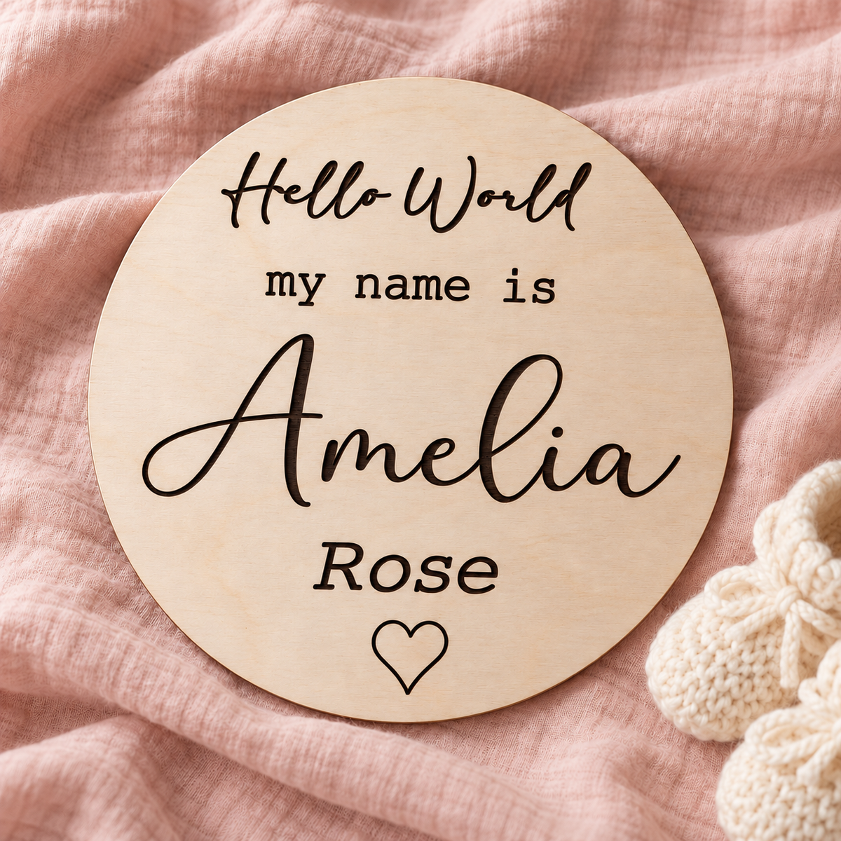 Personalised birth announcement sign engraved Amelia Rose with a heart, styled on soft blush fabric