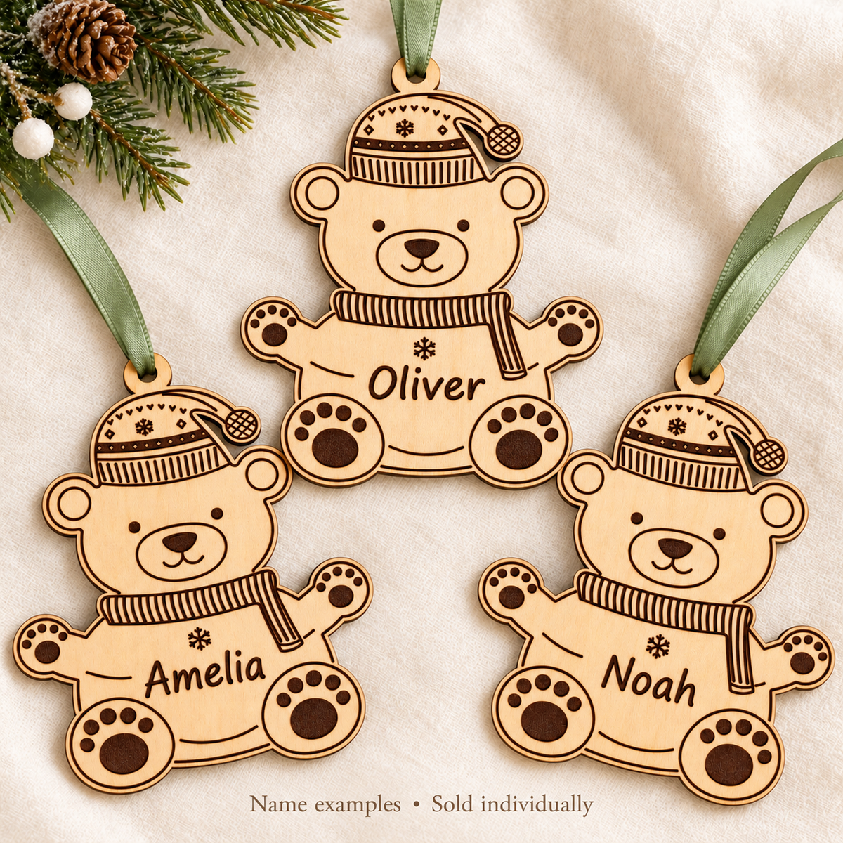 Wooden polar bear baubles engraved with Amelia, Oliver and Noah, showing name examples; each bauble is sold individually.
