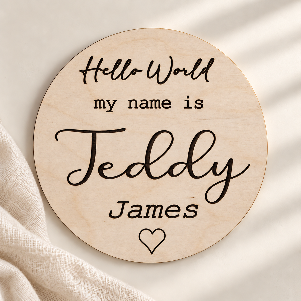 Hello World my name is Teddy James wooden sign with engraved heart on an ivory background