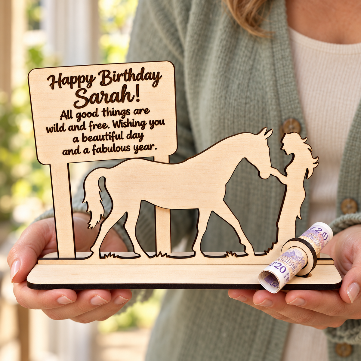 Personalised horse birthday money gift held in two hands, showing its scale and engraved message