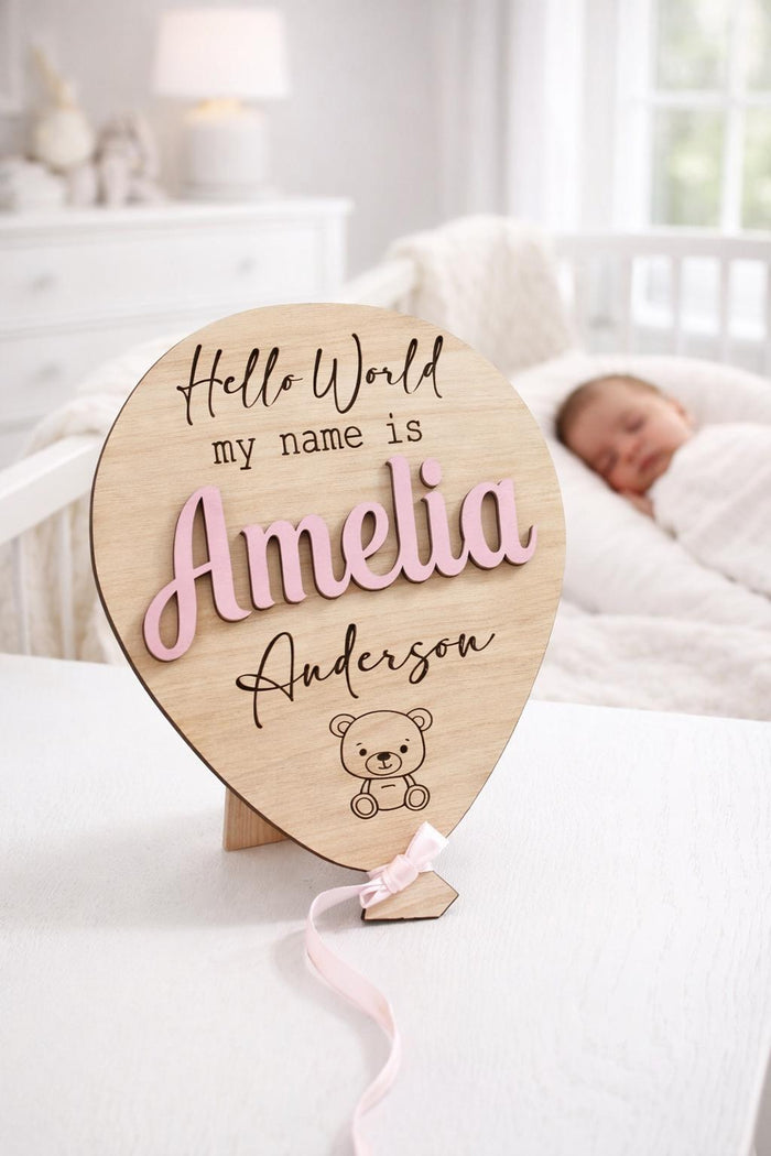 Original Amelia Anderson personalised wooden baby announcement balloon with Pastel Pink raised name and Pink ribbon in a bright nursery.