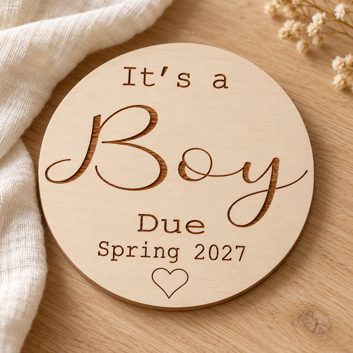 Angled view of the thin birch wooden It's a Boy sign with engraved due date