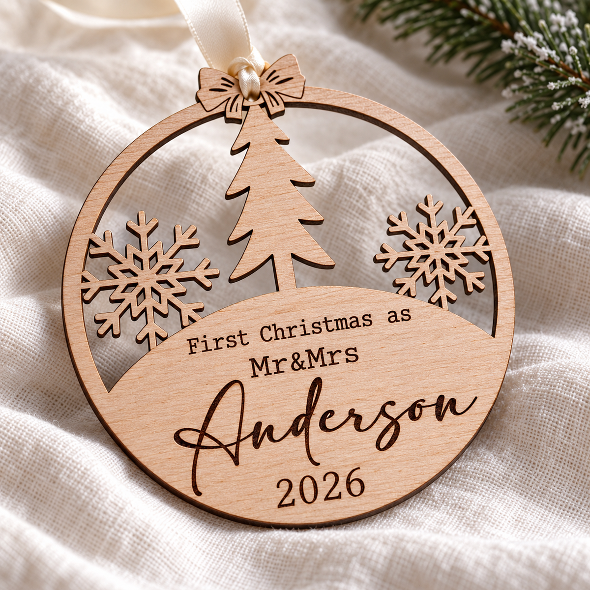 Close-up of laser-engraved Mr and Mrs Anderson surname and 2026 on a natural birch plywood Christmas bauble
