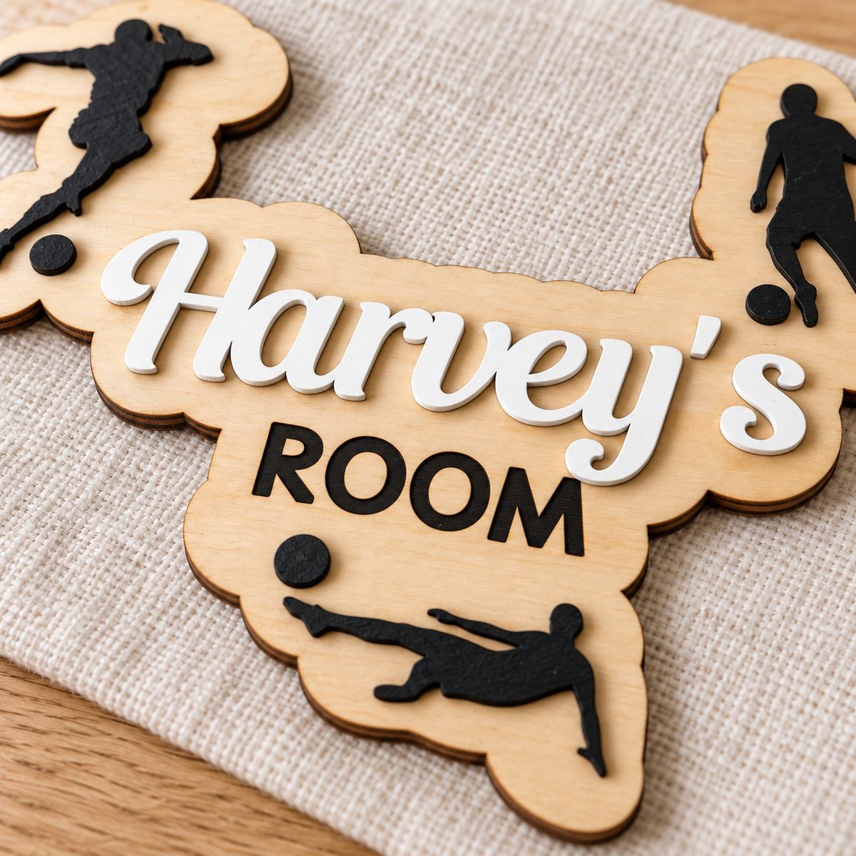 Close-up of the raised painted name, natural wood grain and crisp black ROOM engraving on the football plaque.