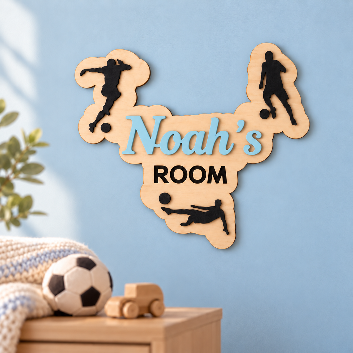 Pastel blue Noah’s ROOM football name sign with a capital N displayed in a nursery.