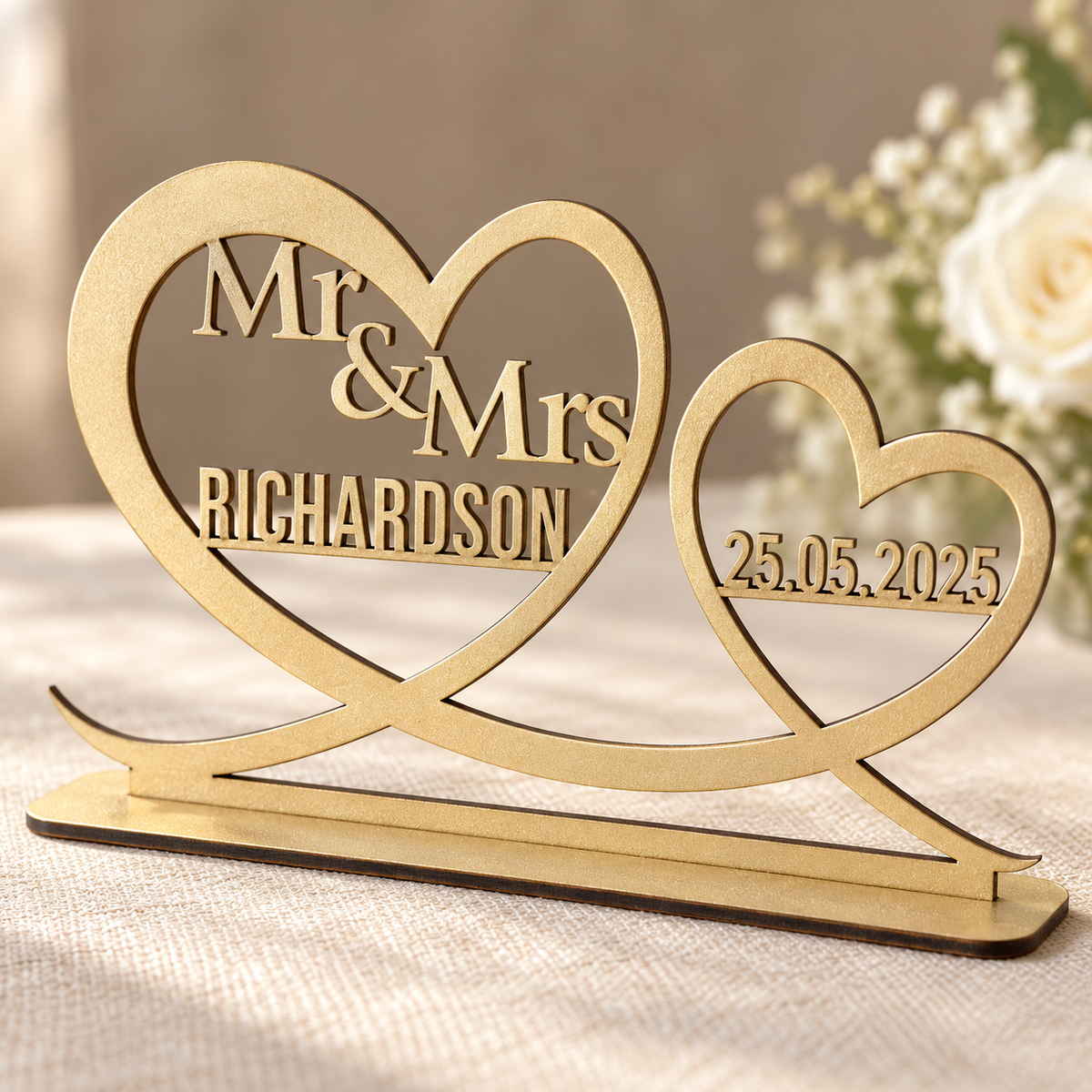Close-up of gold painted wooden Mr and Mrs heart ornament showing laser-cut surname and date