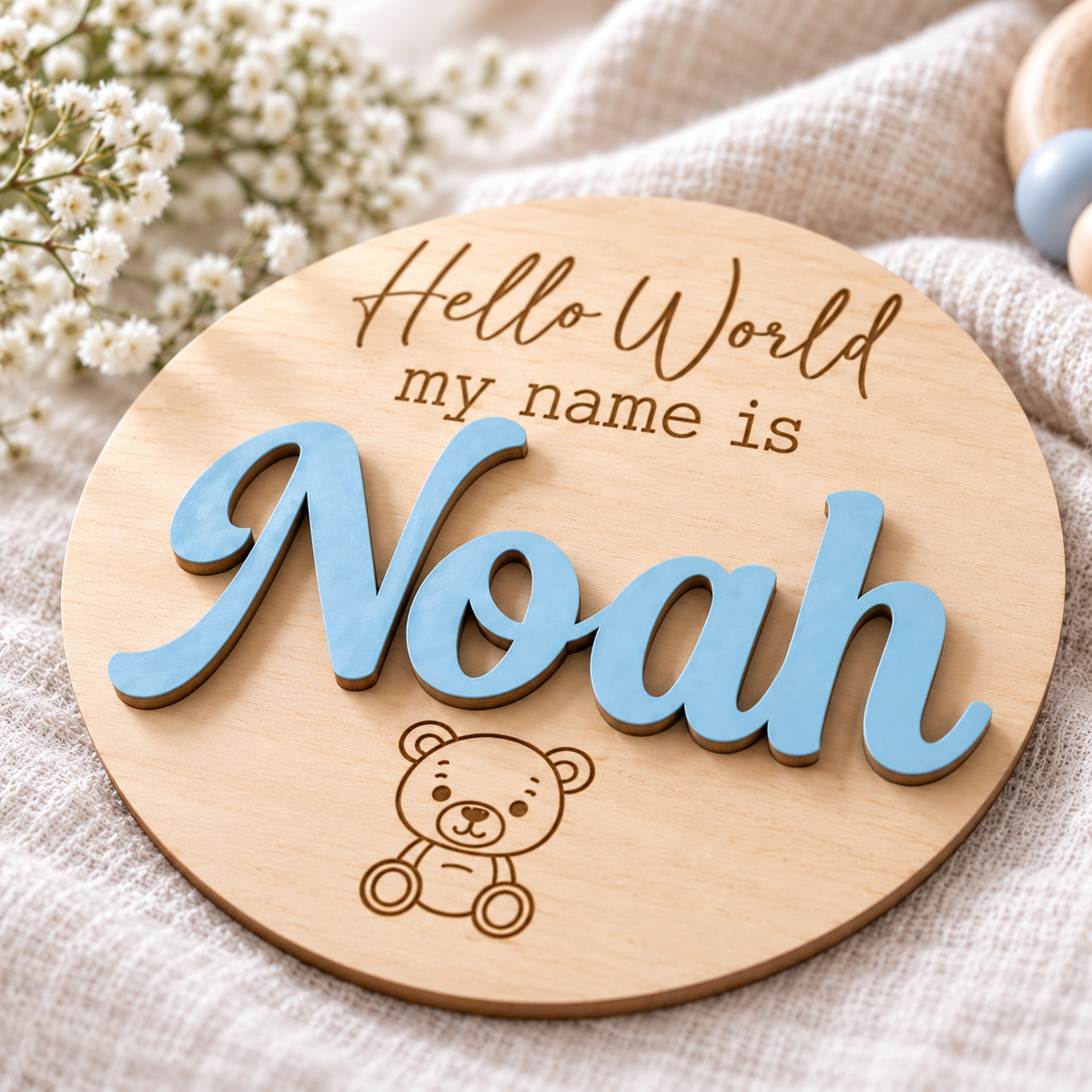 Close-up of raised Pastel Blue Noah lettering and engraved details on the natural wooden Hello World plaque.