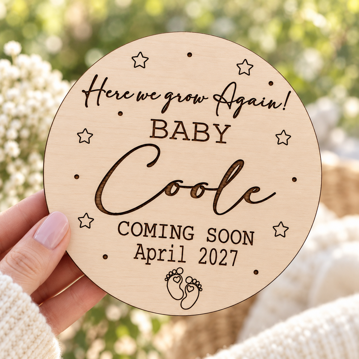 Personalised Here We Grow Again wooden sign held against a bright garden background