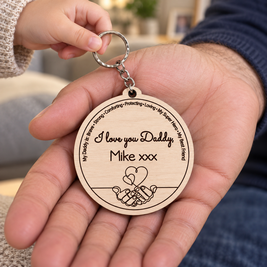 Child giving Dad a personalised I Love You Daddy wooden keyring engraved Mike xxx, with pinky promise hands and hearts