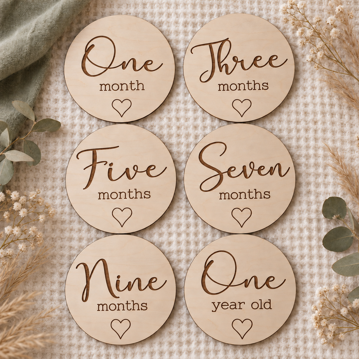 Six script and heart wooden monthly photo markers showing One month, Three months, Five months, Seven months, Nine months and One year old