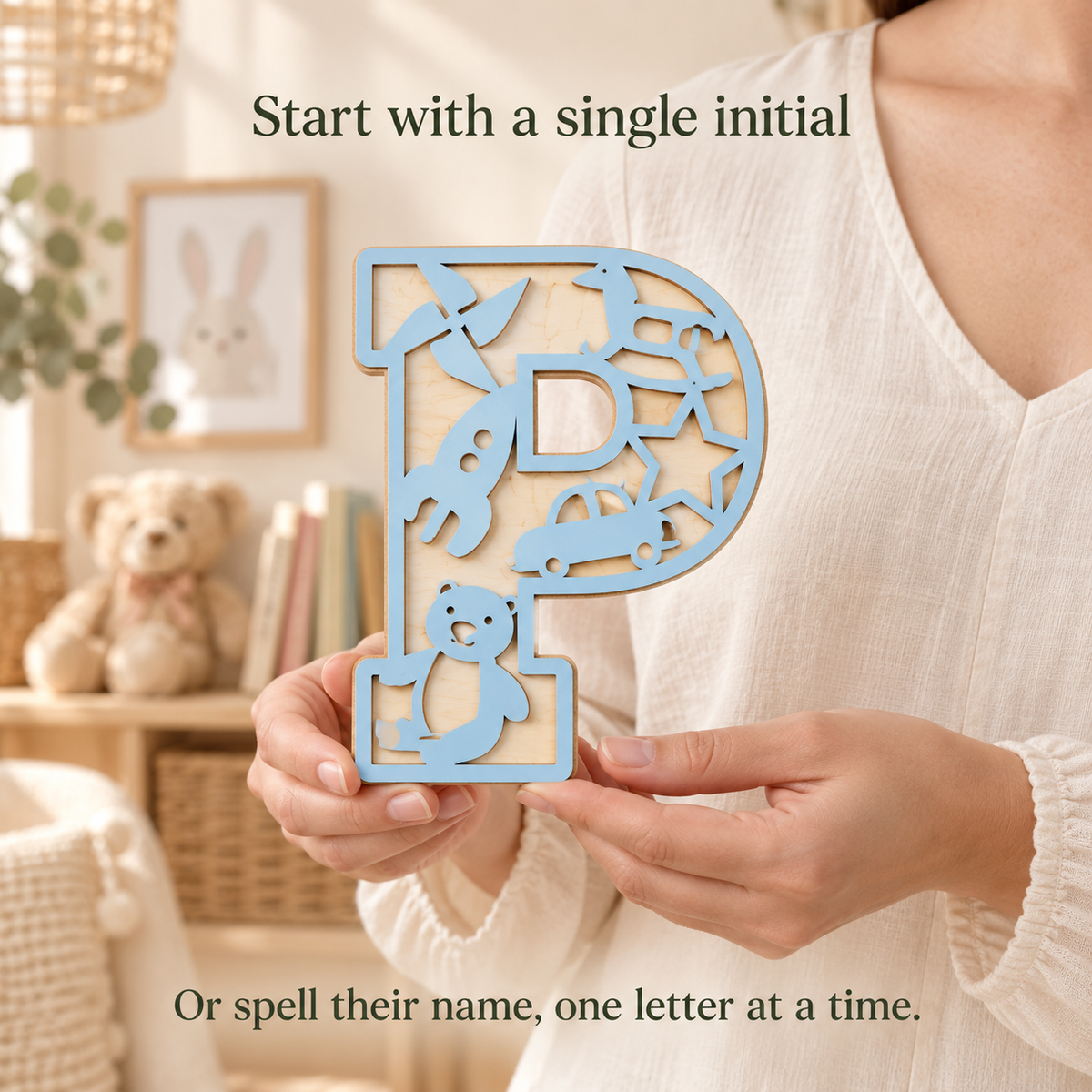 Pastel Blue wooden P initial held in hands, with toy cutout details and a natural birch back layer