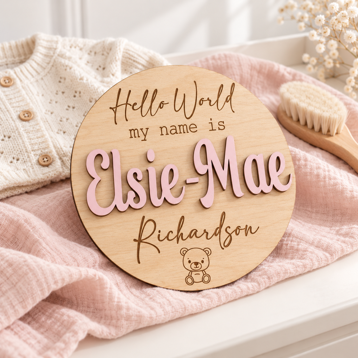 Pastel Pink raised Elsie-Mae name and engraved Richardson surname on a round wooden teddy bear baby name plaque.