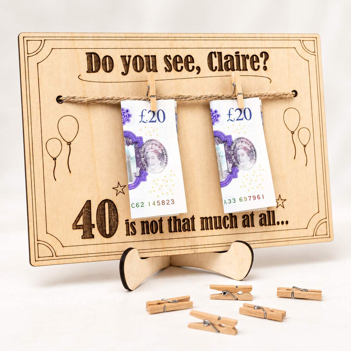 Engraved birthday cash gift with miniature wooden pegs holding banknotes on a twine line