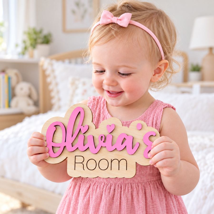 Child holding a pink Olivia's Room personalised bedroom door plaque with raised wooden letters