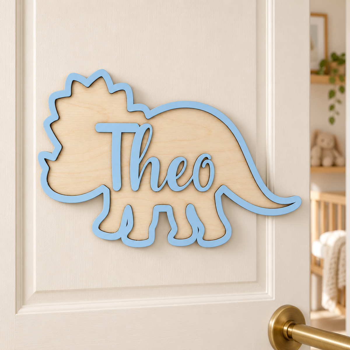 Pastel blue Theo triceratops name sign mounted on a child's bedroom door.