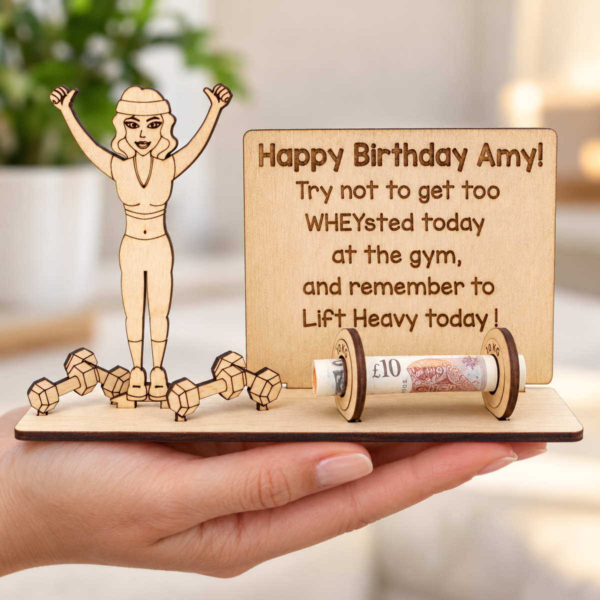 Personalised fitness birthday money holder supported in a hand, showing the assembled wooden gift