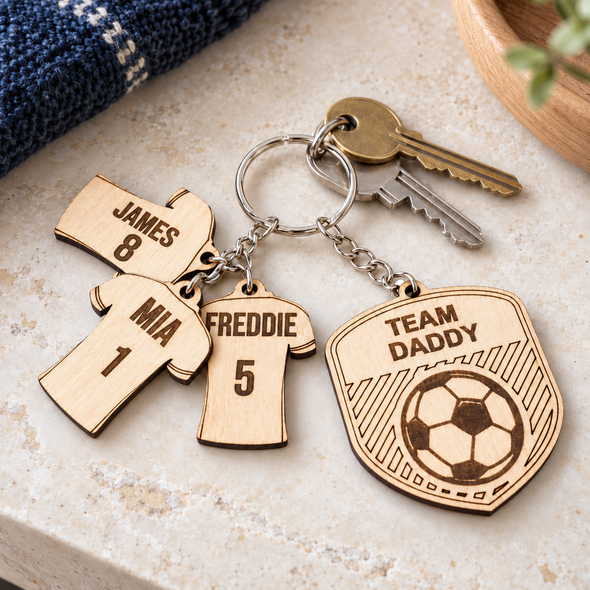 Team Daddy football keyring with three engraved name and number shirt charms beside house keys