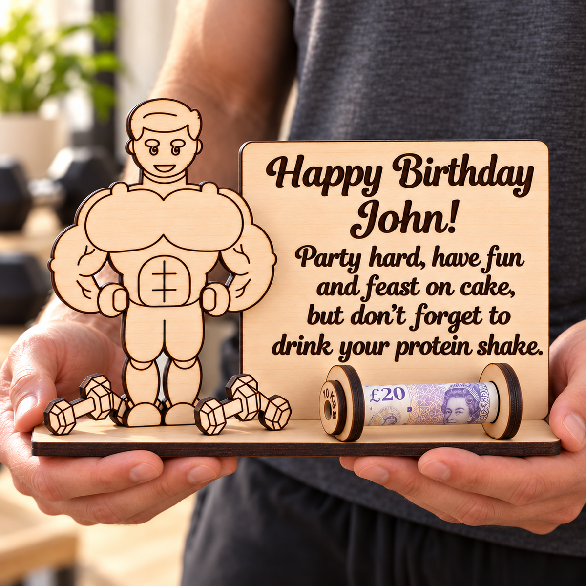 Personalised wooden bodybuilder gym money holder held in two hands to show its size