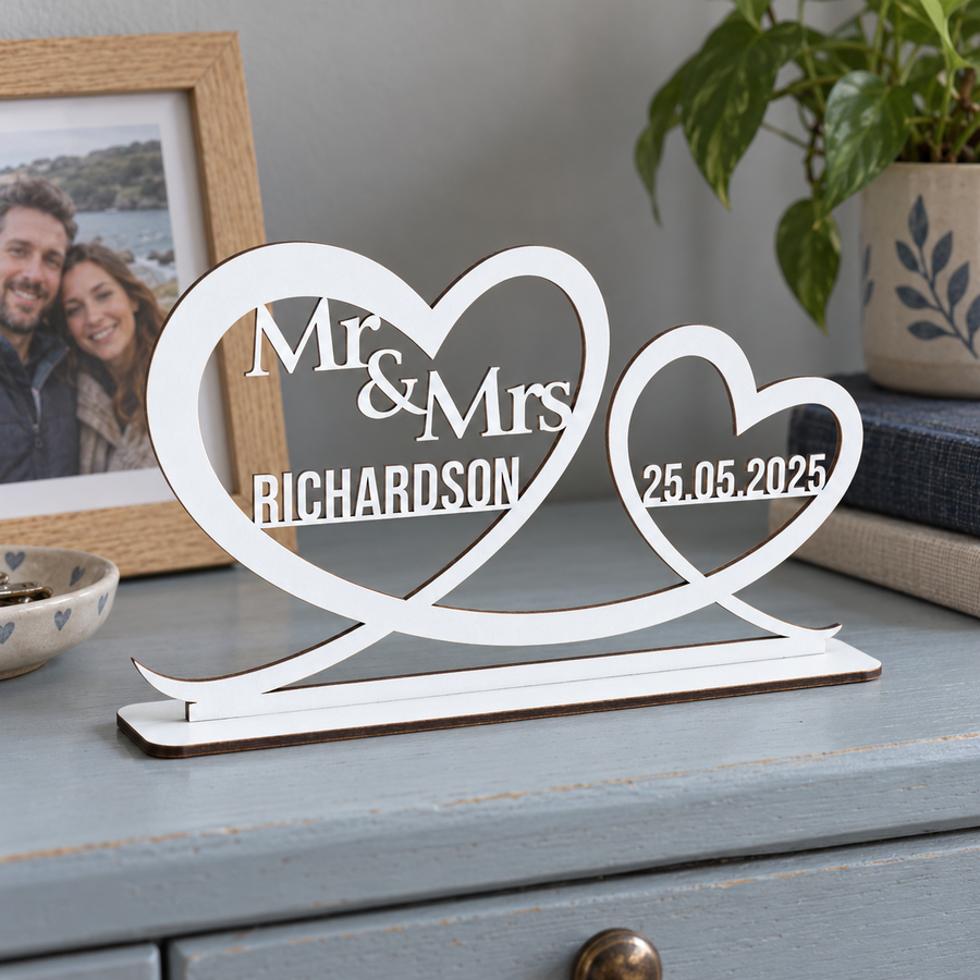 White personalised Mr and Mrs heart ornament with Richardson surname and wedding date on a blue dresser beside a couple photo