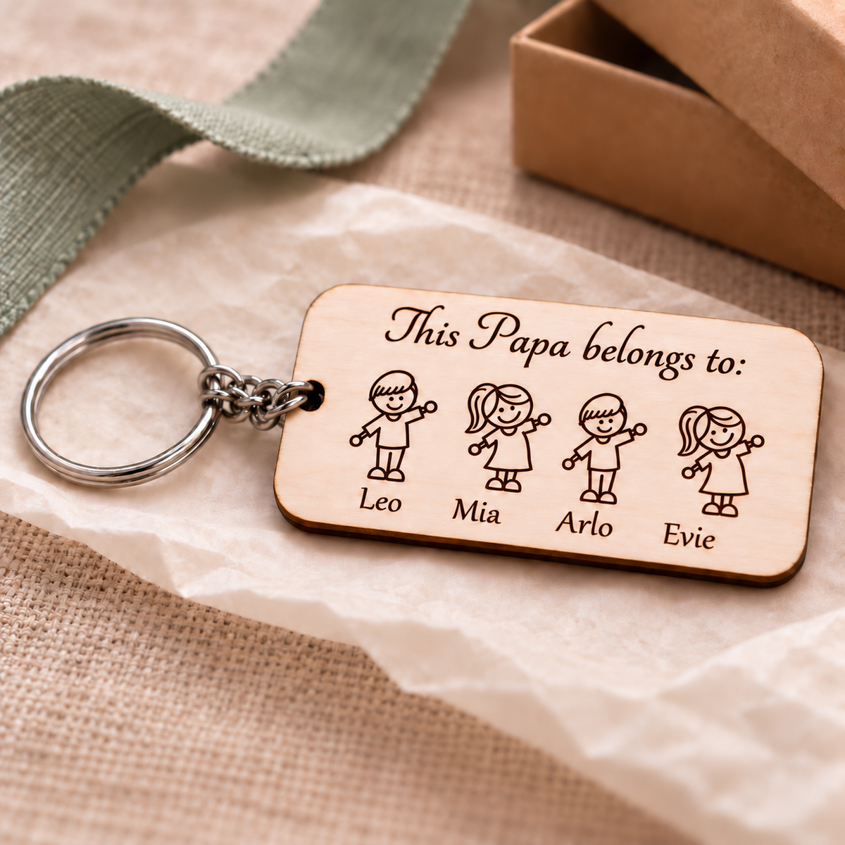 Personalised Papa wooden keyring with four children's names displayed in a gift setting