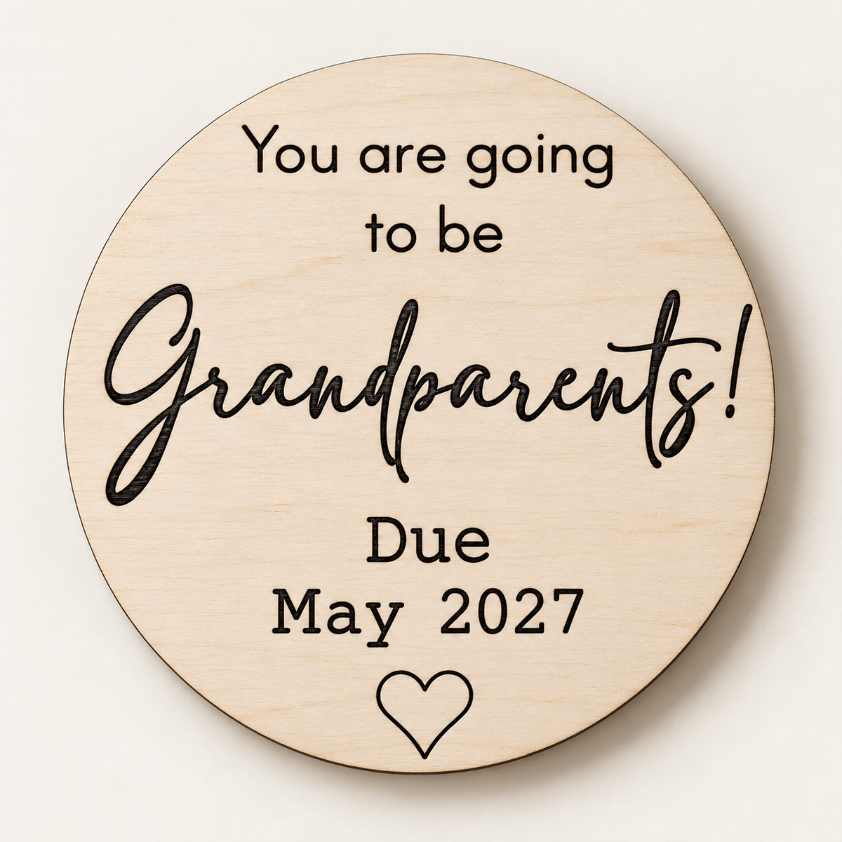 Personalised wooden grandparents announcement disc photographed against a clean cream background