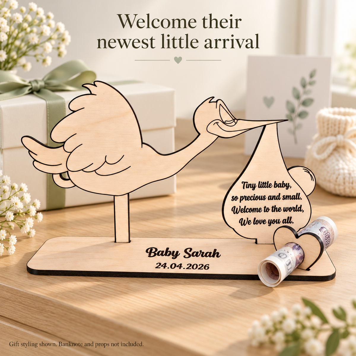 Personalised wooden stork gift styled beside a wrapped present; styling props not included