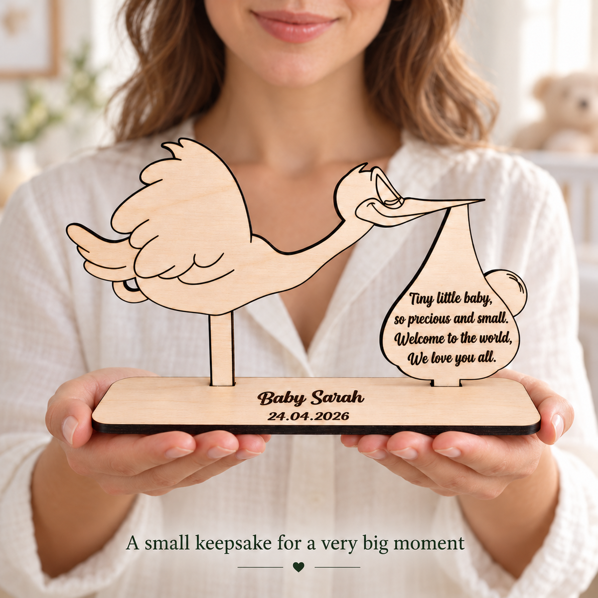 Woman holding a personalised freestanding wooden stork keepsake without money holder