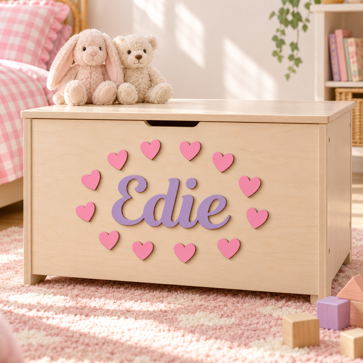 Lilac wooden name Edie and 12 pink hearts attached to a wooden toy box in a child's room