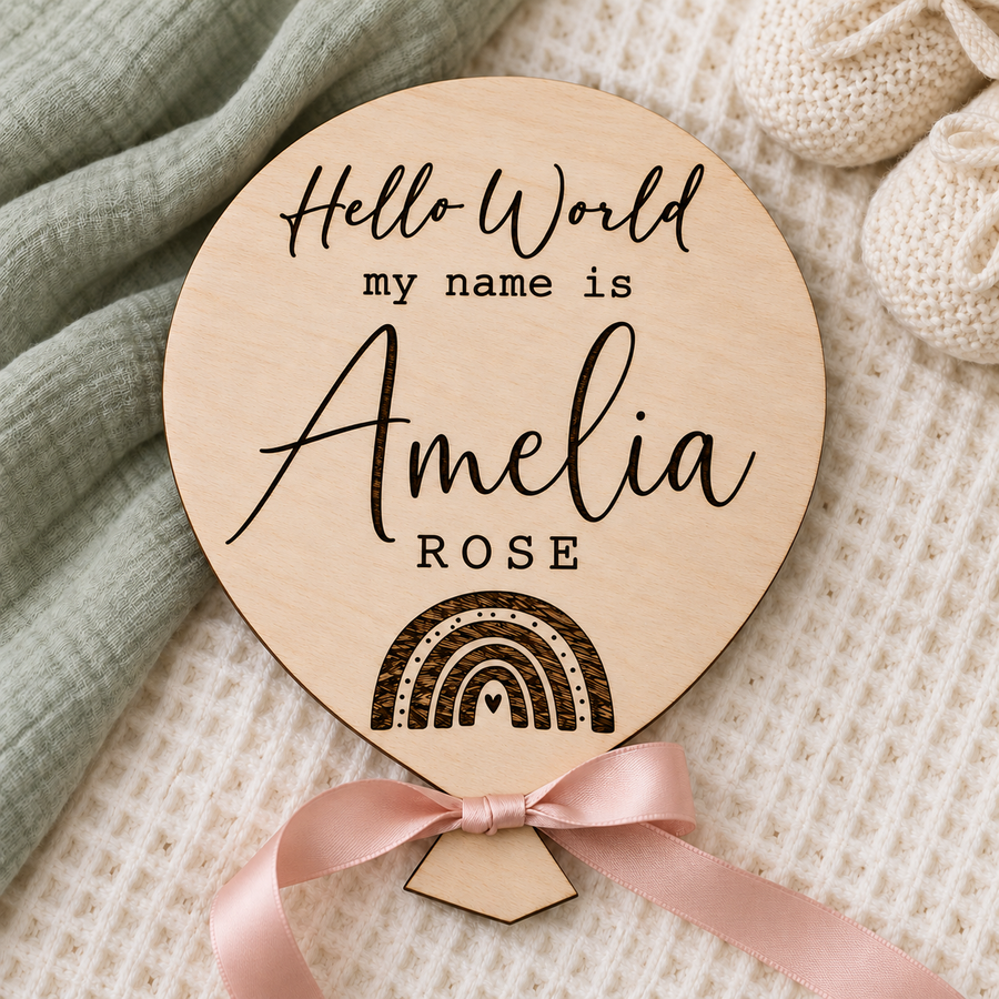 Personalised wooden rainbow name plaque with Hello World wording and pink satin bow on cream fabric