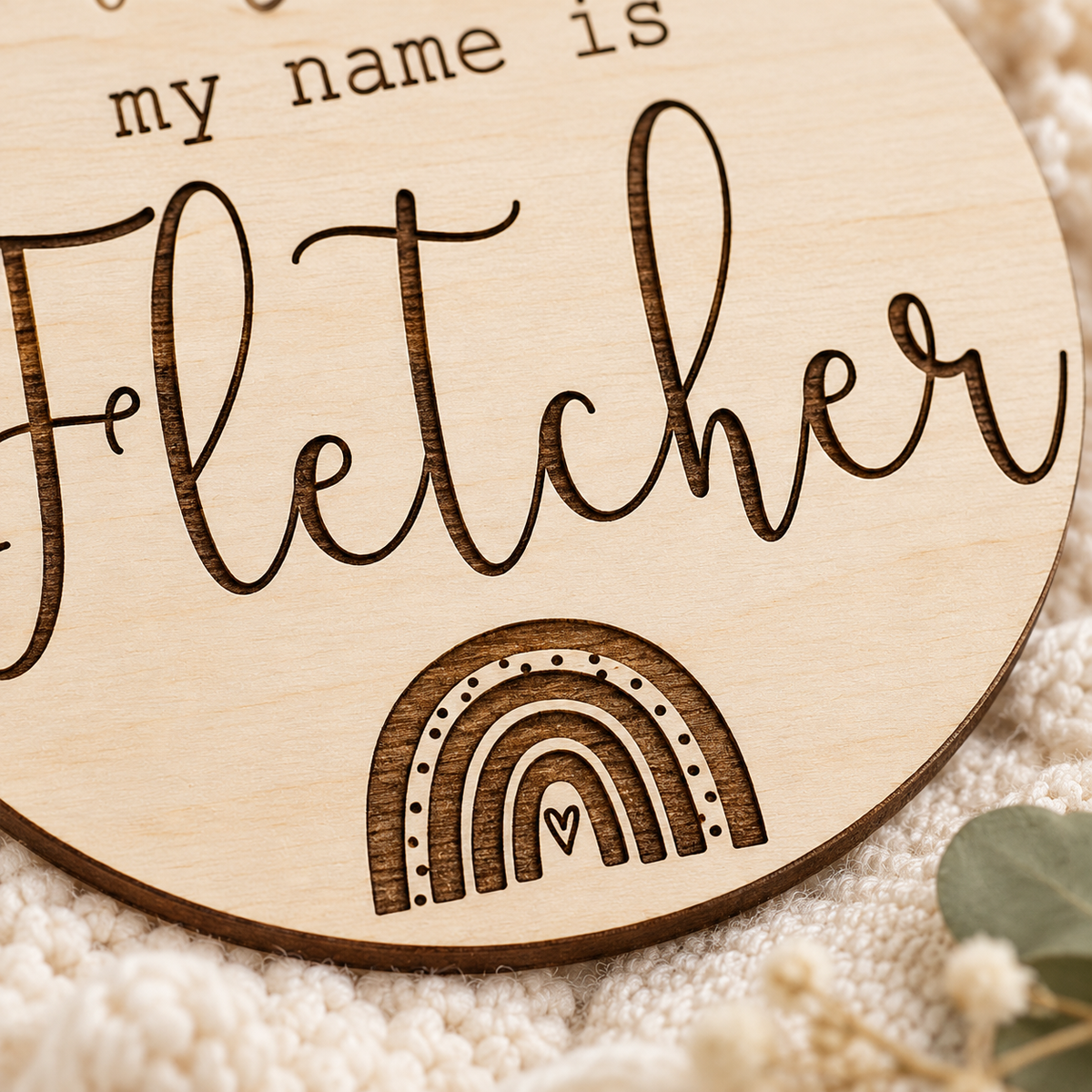 Close-up of the engraved rainbow and lettering in natural birch wood