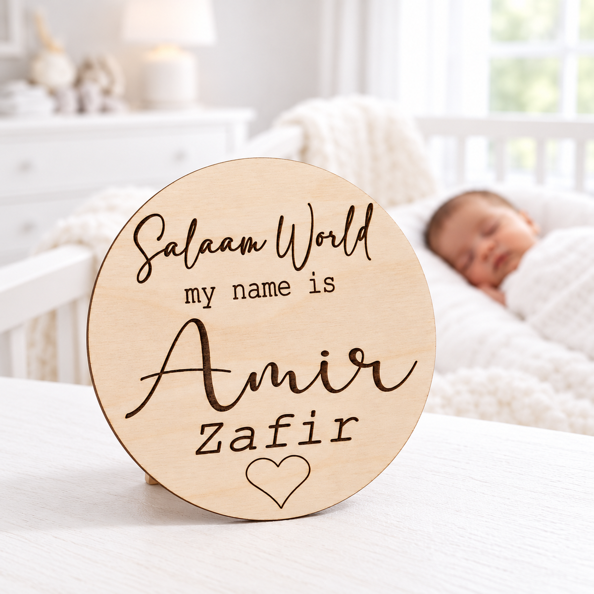 Personalised Salaam World wooden baby name plaque engraved with Amir Zafir, displayed in a bright nursery with a newborn in the background