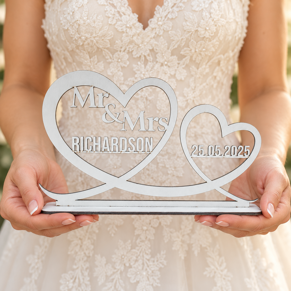 Silver personalised double heart wedding keepsake held in hands to show its size and freestanding base