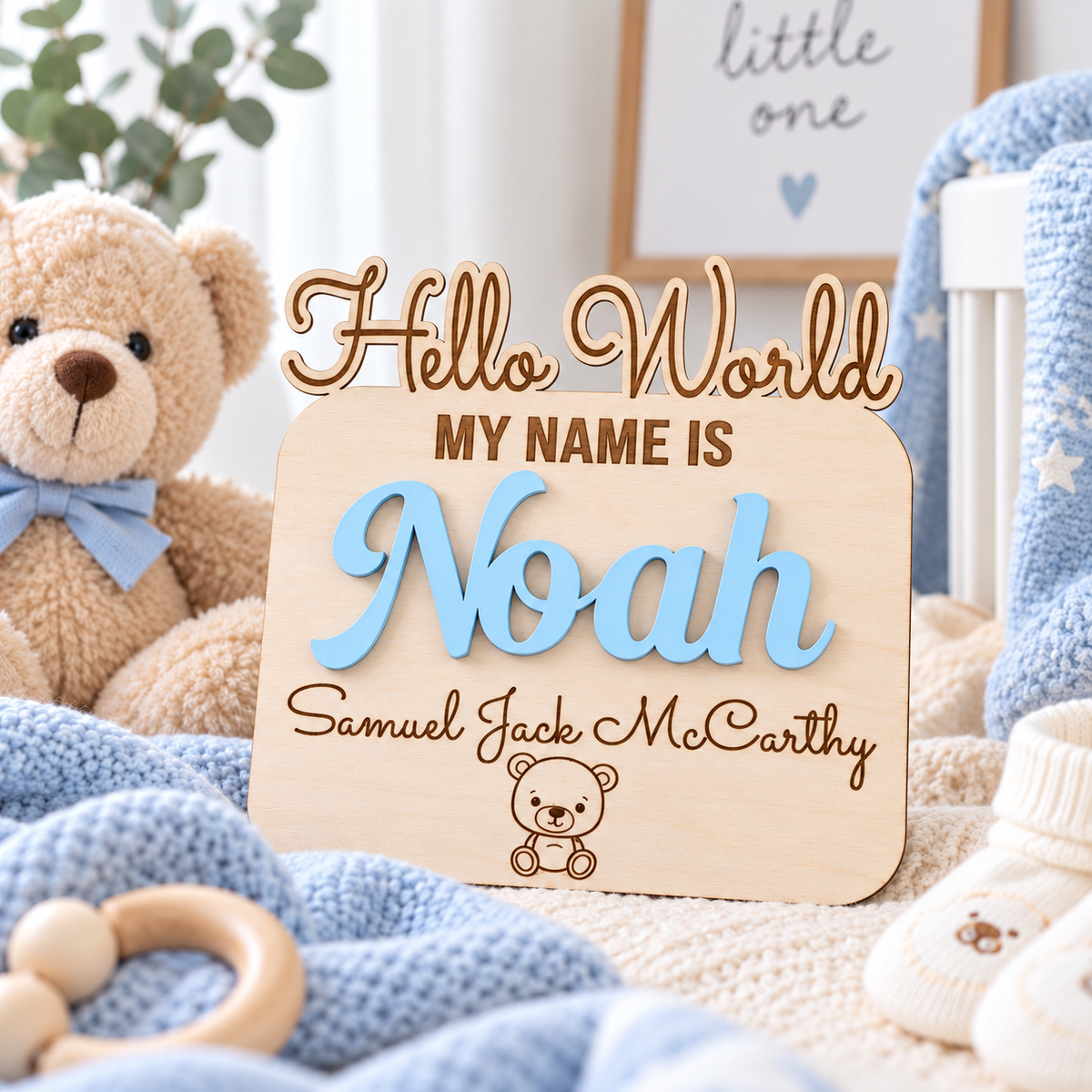Personalised Noah newborn keepsake plaque with raised blue wooden letters, engraved names and a teddy detail in a bright nursery.