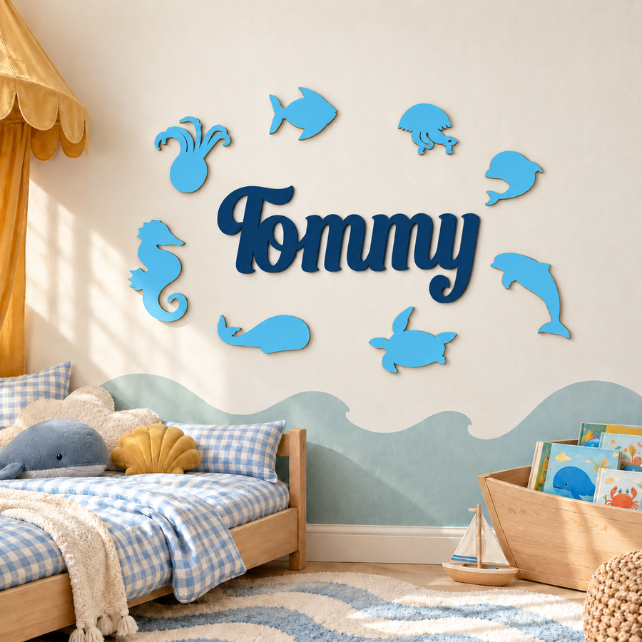Navy Blue Tommy wooden name sign with eight Pastel Blue sea animals on an ocean-themed nursery wall