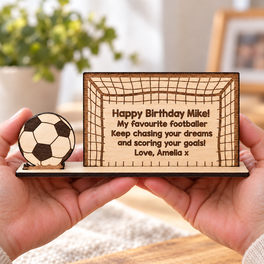 Personalised wooden football gift held in hands with a birthday message for Mike, a football and display base, without banknote holder.