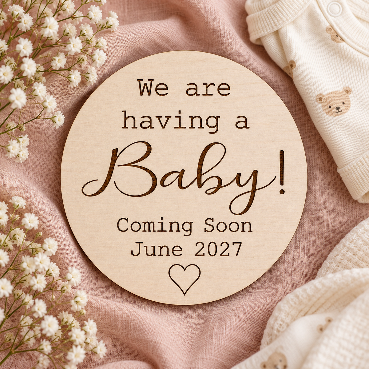 Alternative Coming Soon wording and June 2027 date on a We are having a Baby plaque styled on blush linen