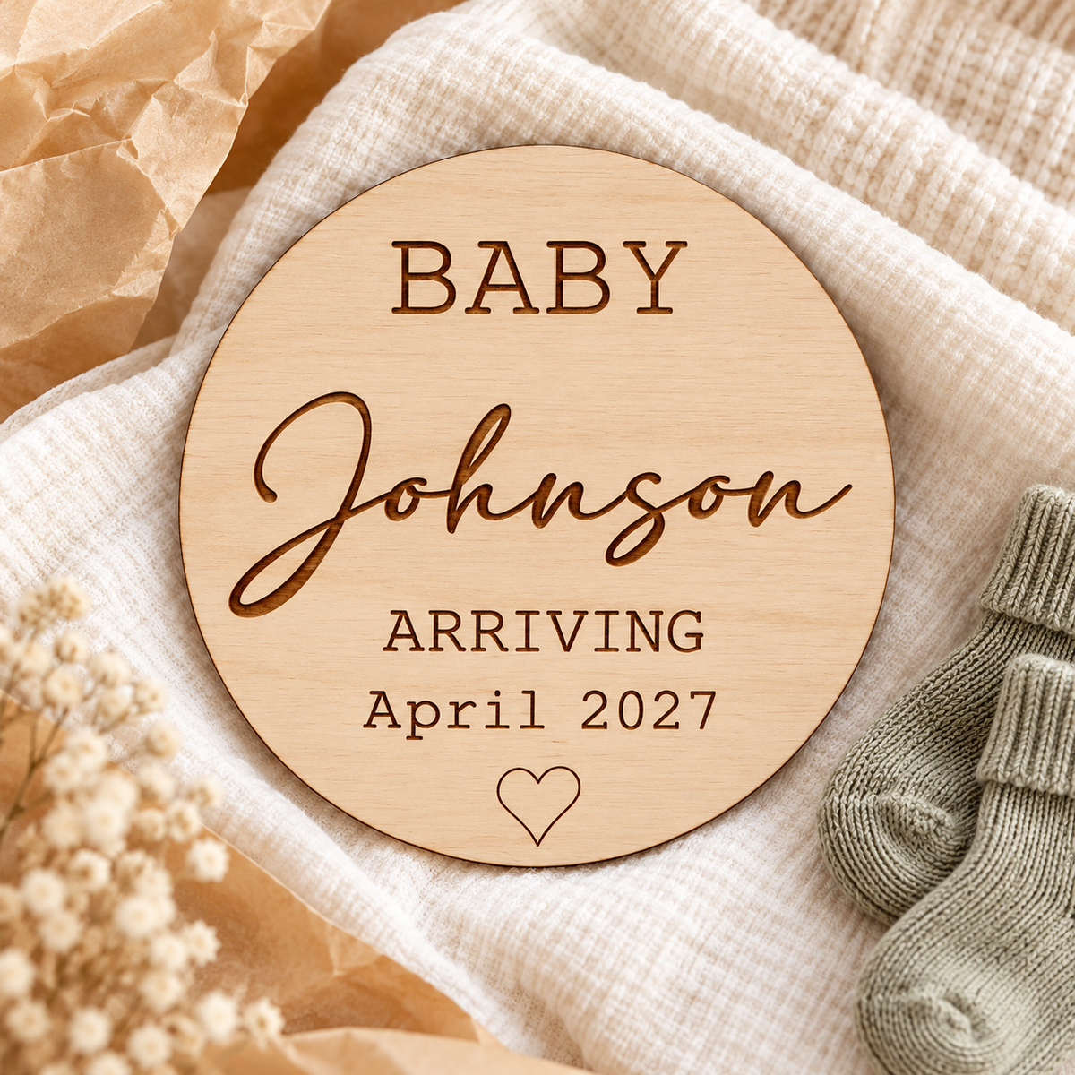 Round personalised Baby Arriving keepsake on cream fabric with baby socks