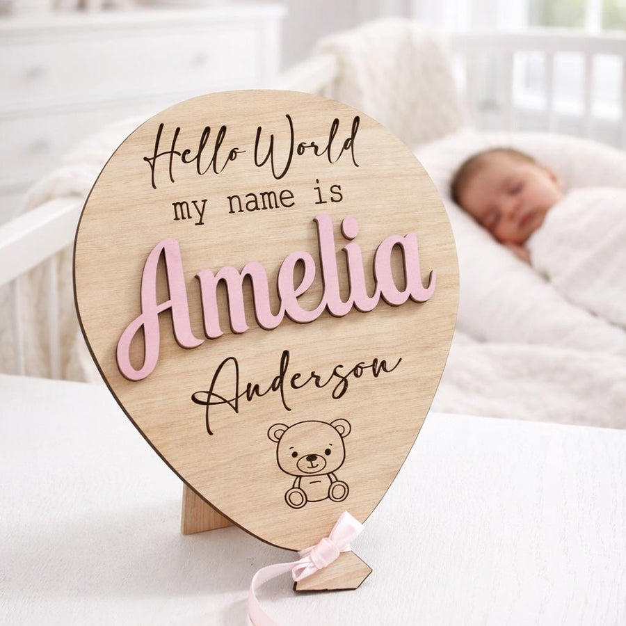 Original Amelia Anderson personalised wooden baby announcement balloon with Pastel Pink raised name and Pink ribbon in a bright nursery.