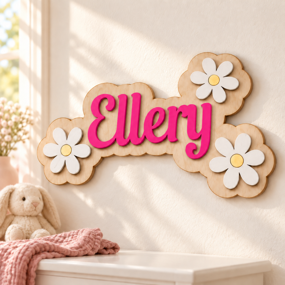 Ellery single-name wooden plaque with raised Deep Pink lettering and three white daisies above a bedroom dresser.