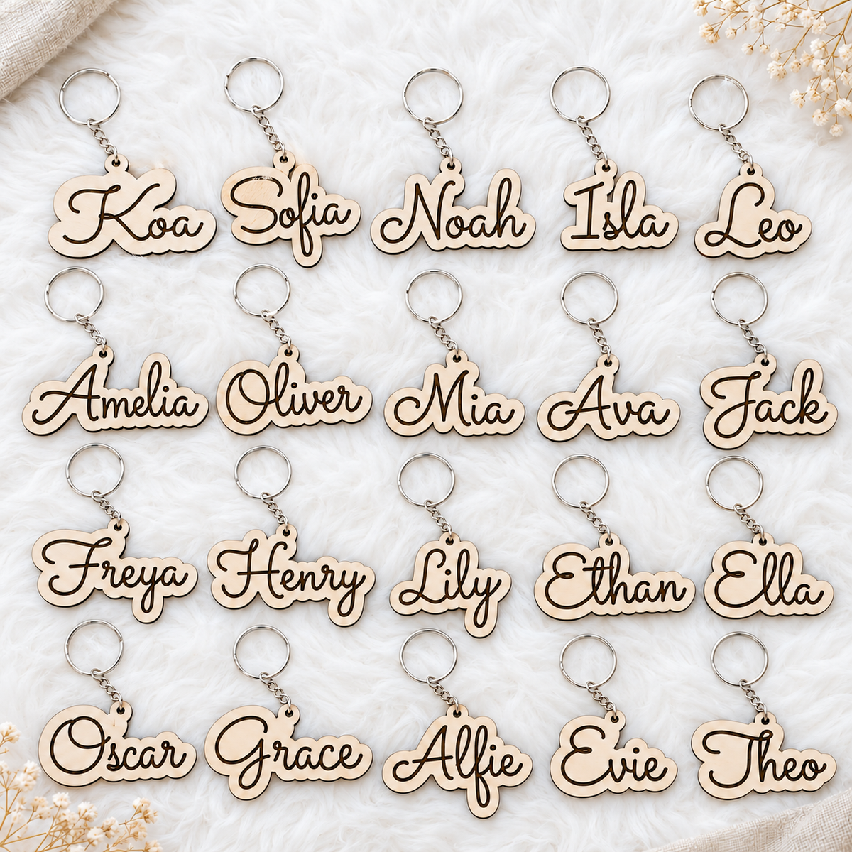 A bulk set of twenty wooden name keyrings with different engraved names, each complete with a metal ring and chain.