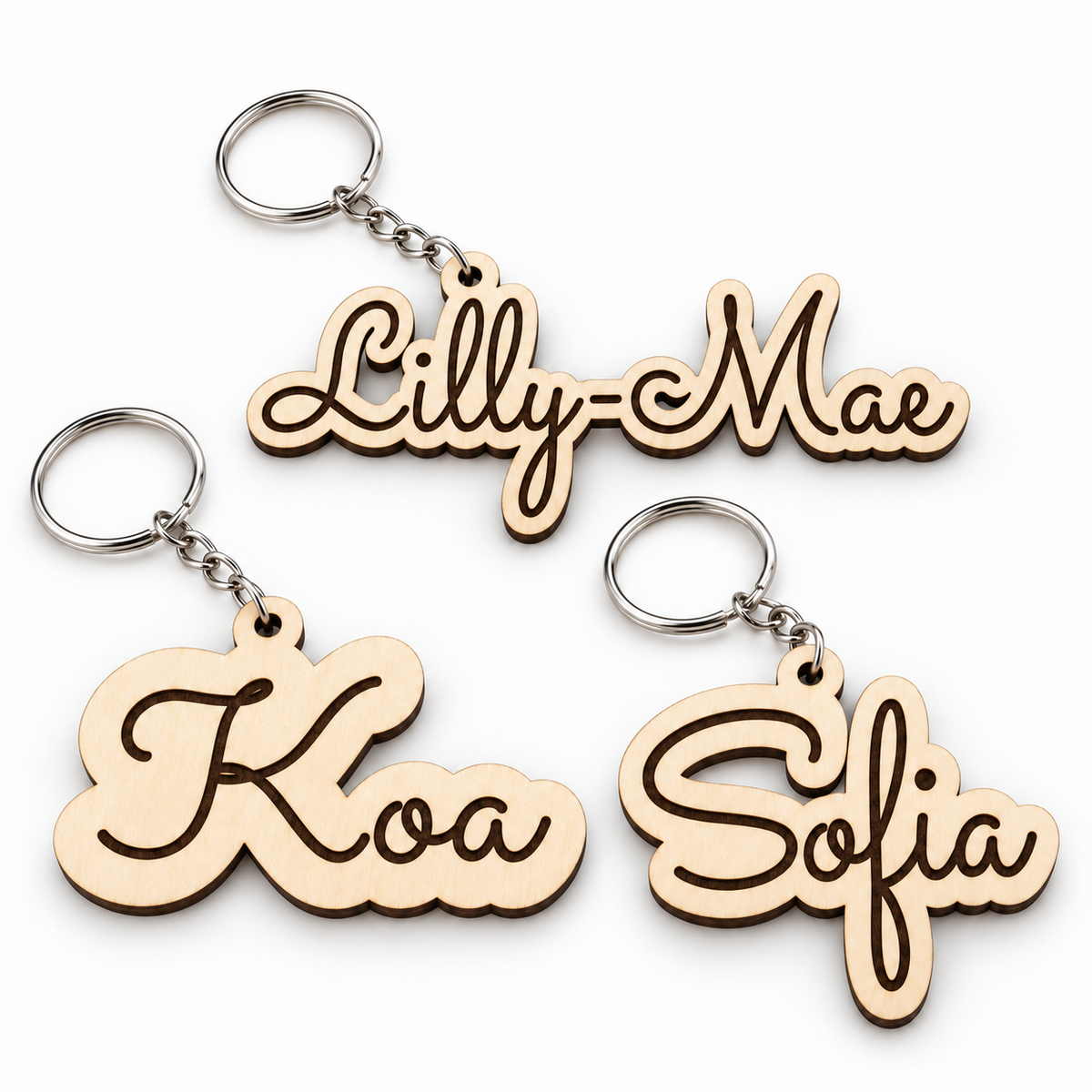 Three natural wooden name keyrings for Lilly-Mae, Koa and Sofia with silver-tone rings and short chains on a white background.