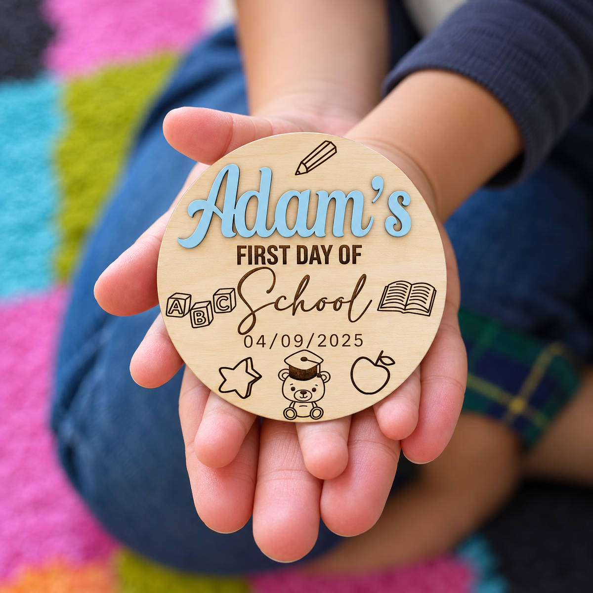 Close-up of the engraved first day of school disc held in a child's hands