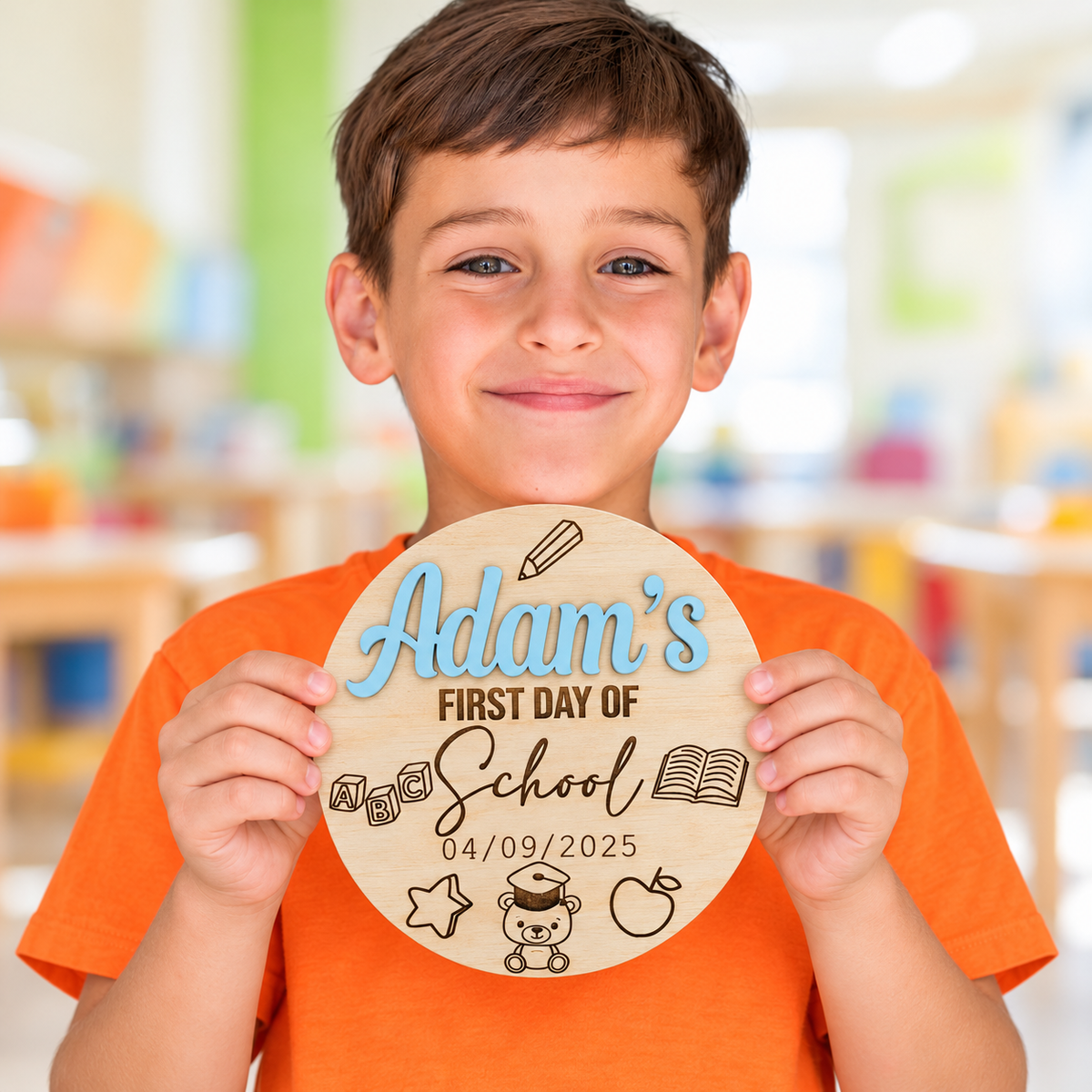 Child holding a personalised wooden first day of school sign with a raised pastel blue Adam's name