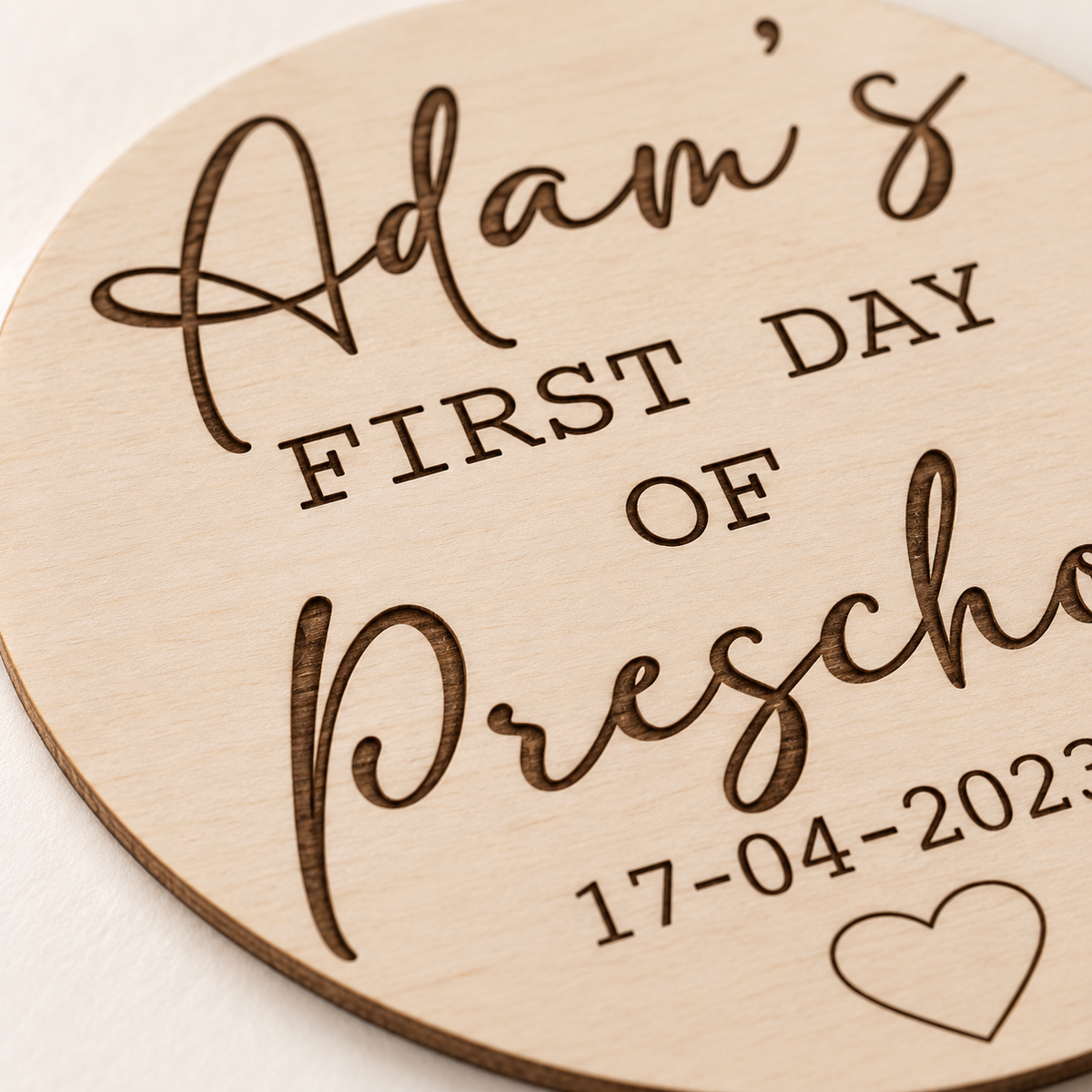 Close-up of engraved lettering and the thin birch plywood edge of a first day sign
