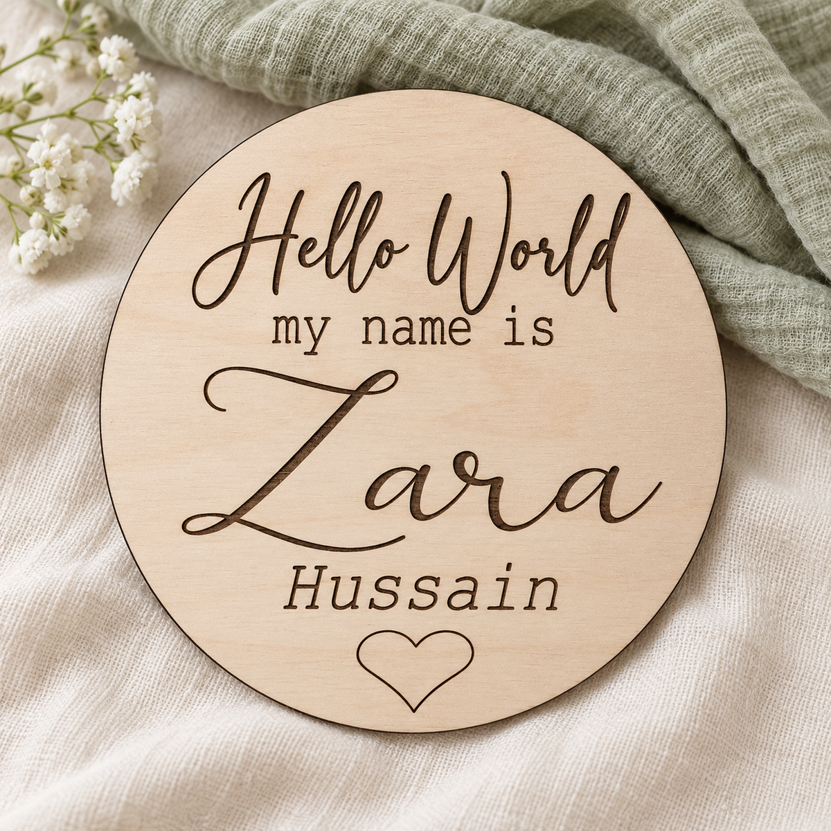 Alternative Hello World greeting on a wooden baby name disc engraved with Zara Hussain